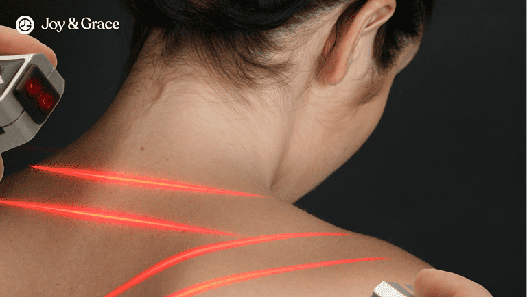 a woman with her arm in front of a red laser tattoo on her back