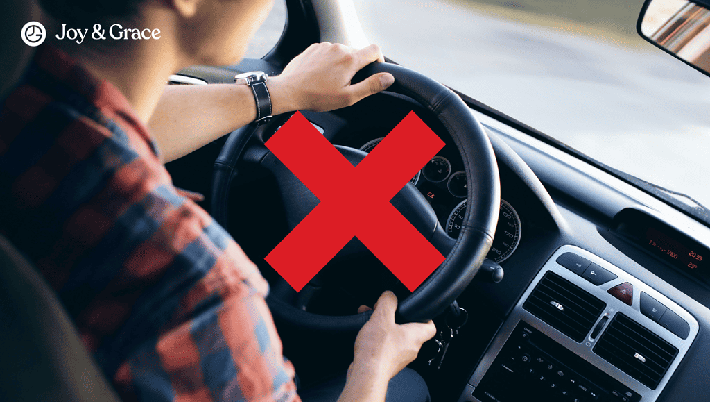 the man is driving his car, holding a steering wheel with both hands