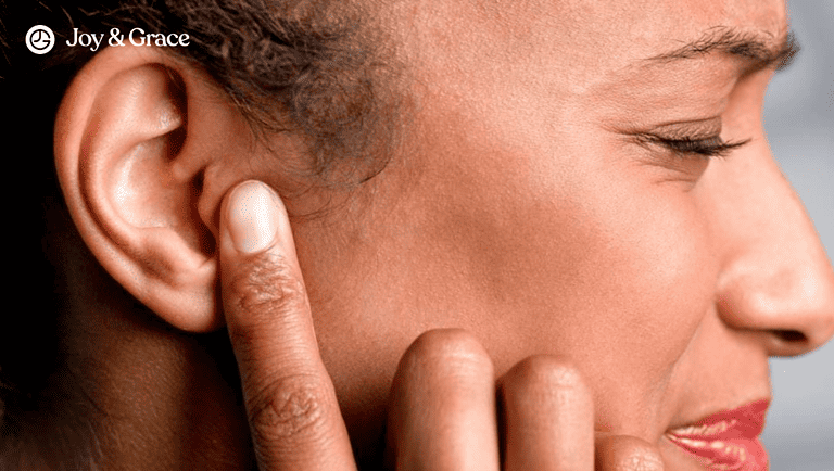 a young woman with her hand on her ear