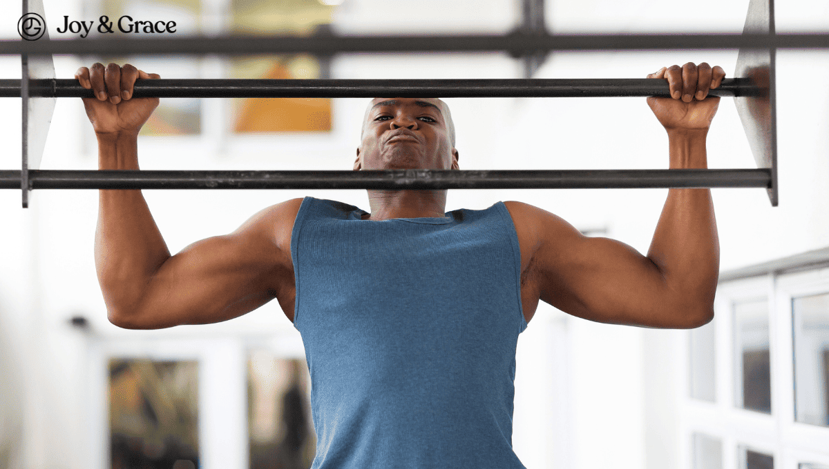 a man is standing at the gym holding onto bars