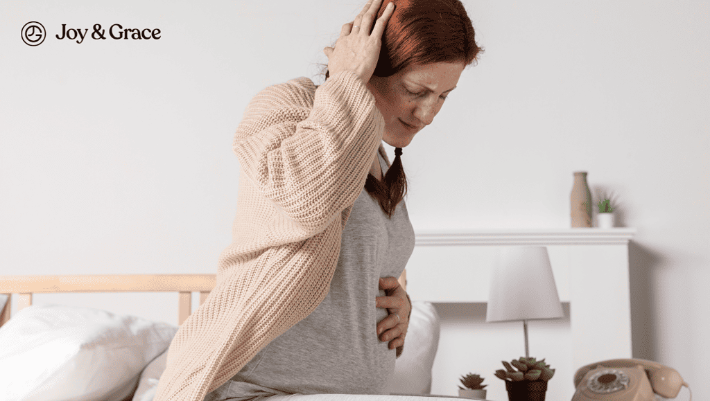 a pregnant woman is sitting on the bed holding her hand over her head