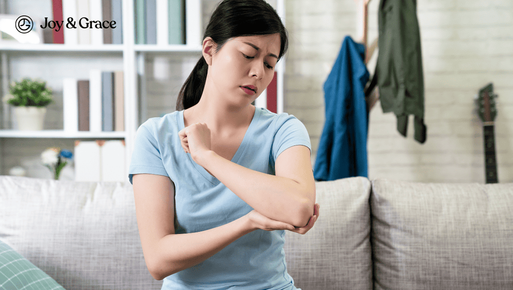 a woman rubbing her elbow while sitting on a couch