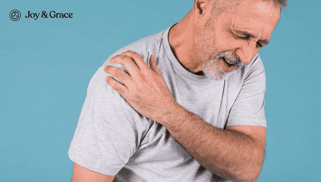 old man in pain while holding his shoulder