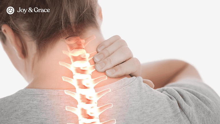 A person rubbing the back of their right neck with potential pain ahd aches radiating through their upper spine