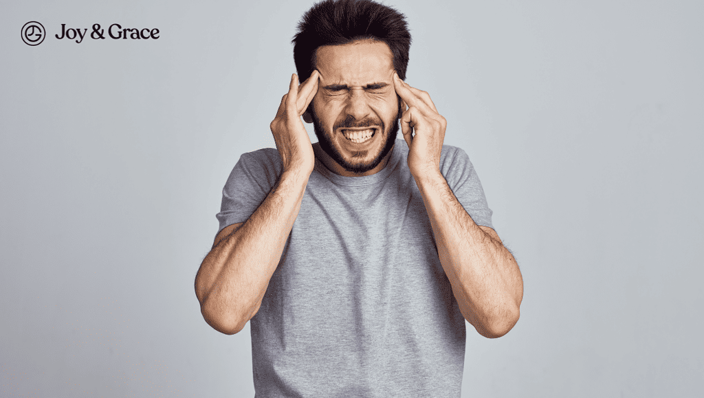 man in gray shirt holding up his head