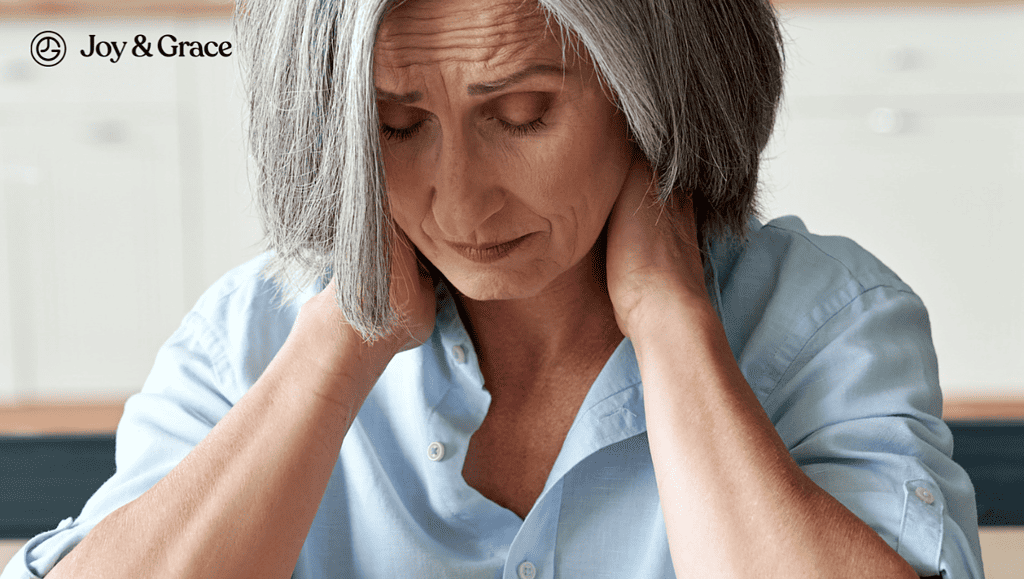 a person with gray hair holding her neck