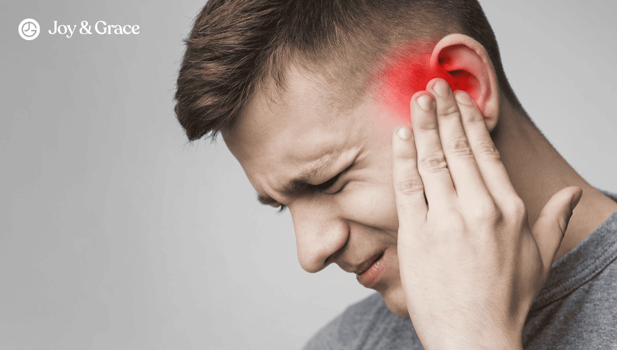 a man holding his ear with an intense headache