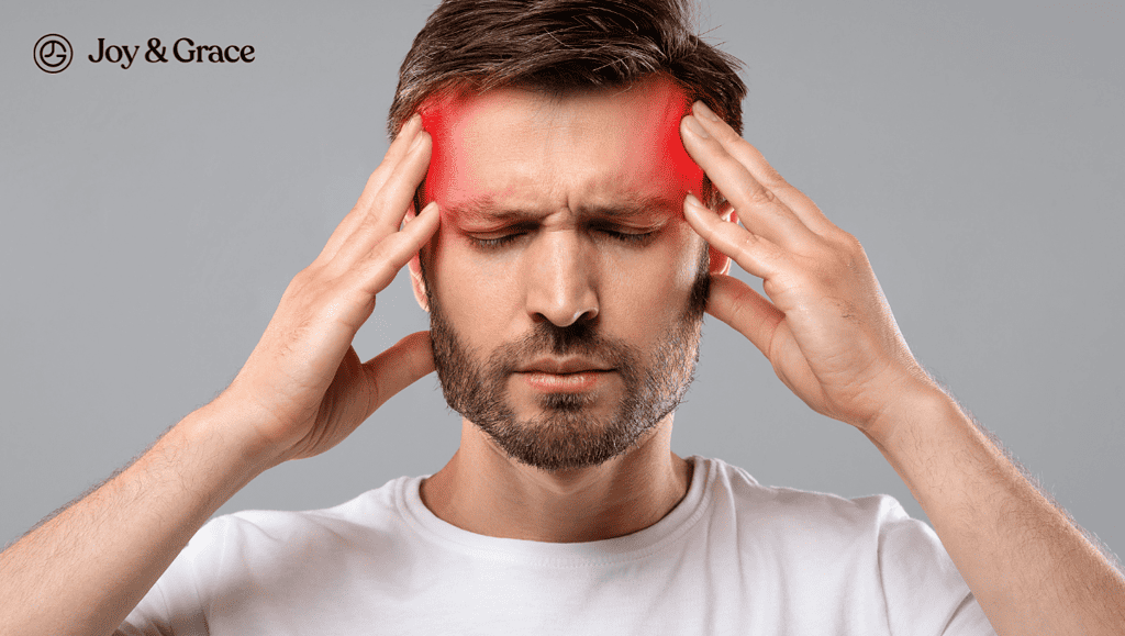 a man has his hand on his forehead and is pressing his head in pain