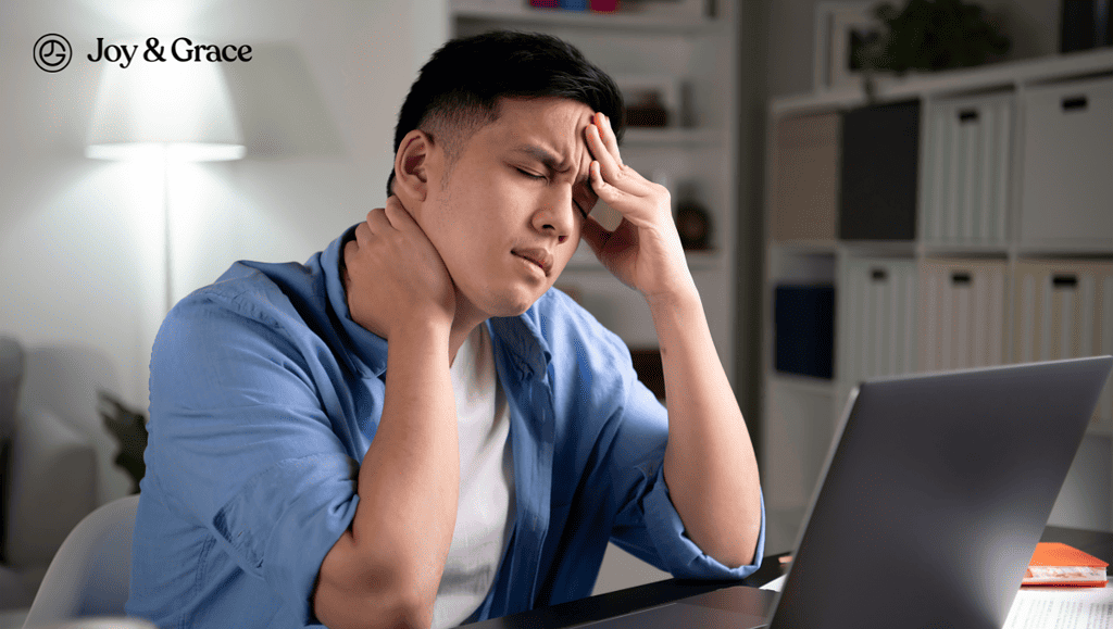 a man has his head and neck while working on his laptop