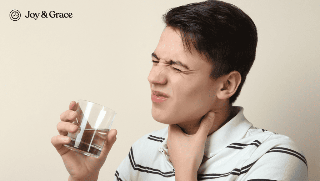 a man holding his throat and drinking from a glass