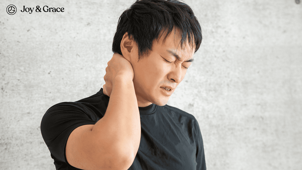 A man in pain using his right arm to rub the back of his neck