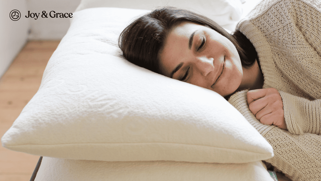 a young lady laying on top of a bed with a pillow