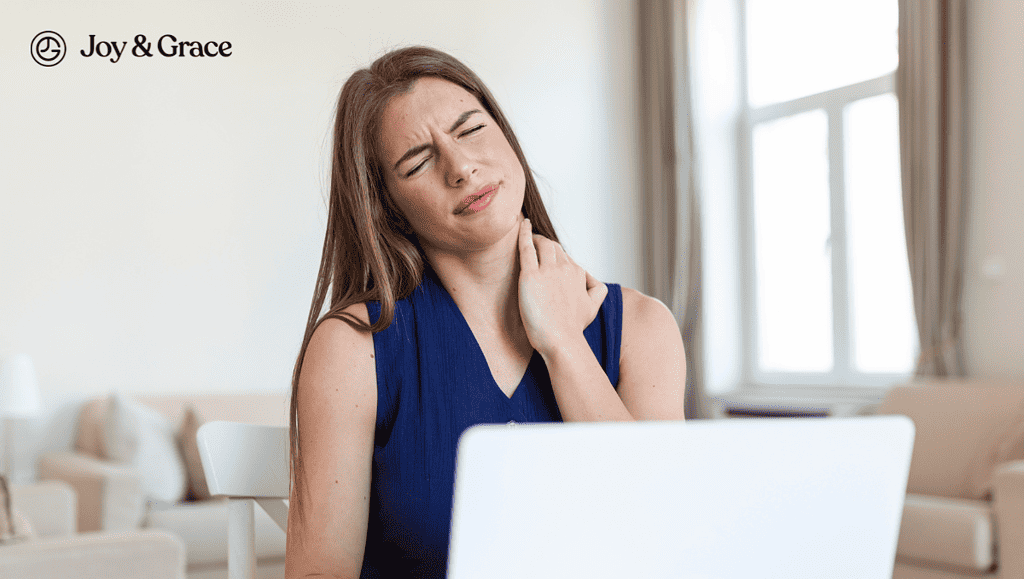a woman has pain at her neck while working on her laptop