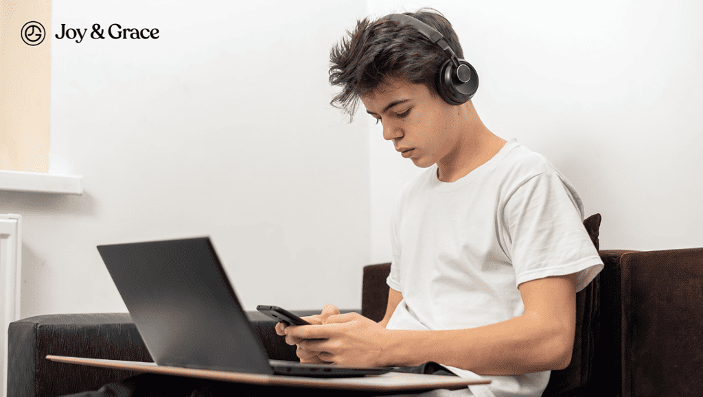 a young man wearing headphones while using his laptop computer