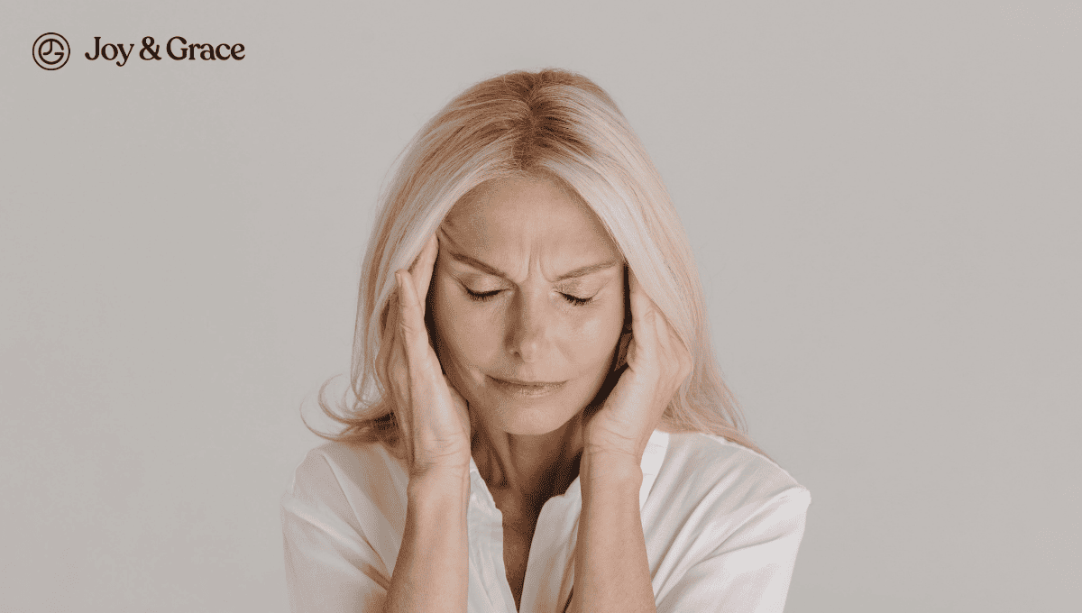 a woman holding her hands to her temples and leaning her head