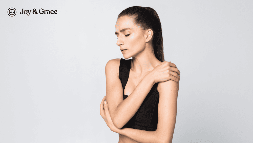 Woman in discomfort and rubbing her left shoulder