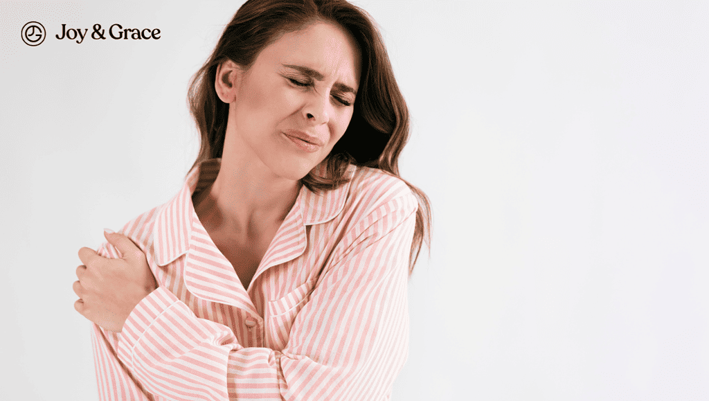 a woman in pajamas is rubbing her shoulder pain