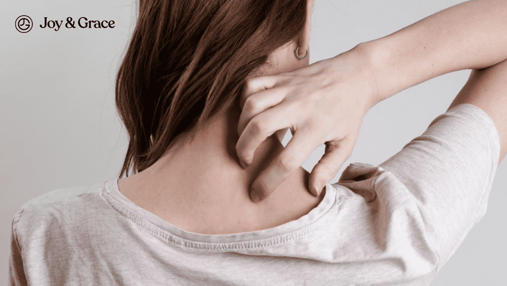 A woman scratching the right side of the back of her neck with her right hand