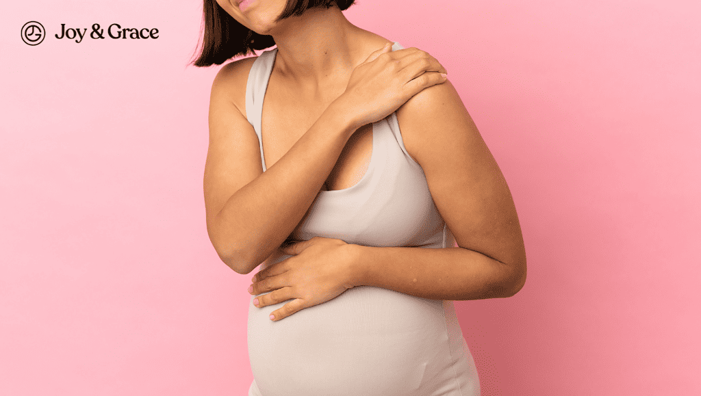 a pregnant woman touching her shoulder
