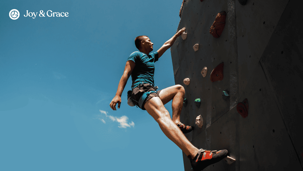 man is climbing up the side of a wall with a rock wall