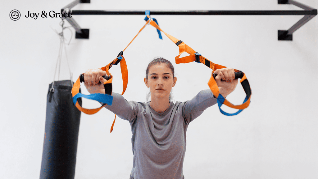 a young woman holding two straps in one hand and lifting one