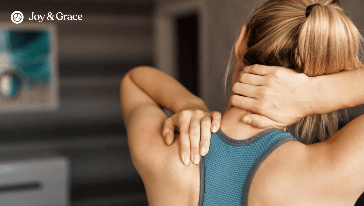 woman standing with hands on her neck and shoulder