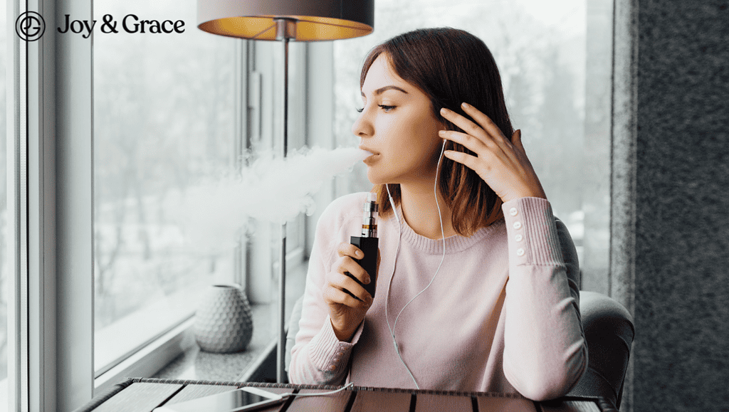 woman sitting at a table while vaping