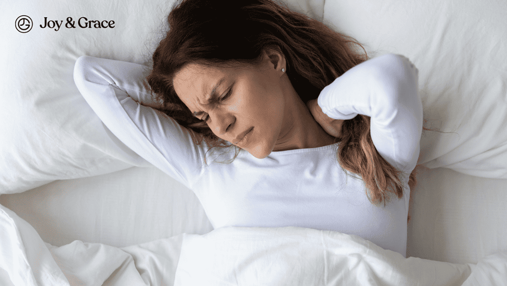 a woman lying in bed touching her neck pain