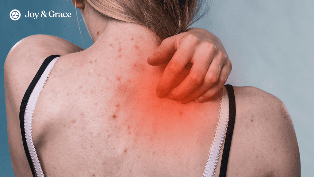 A woman suffering from shoulder pain is holding a red light on her back.