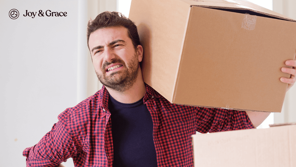 A person enduring rotator cuff pain carrying a cardboard box.