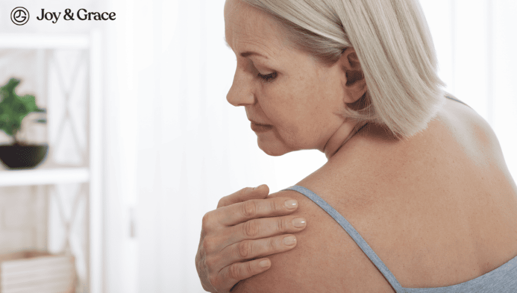 A woman is holding her shoulder in bursitis pain.