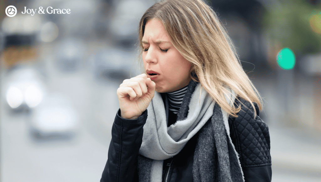 A woman is sneezing on the street, showing symptoms of coughing.