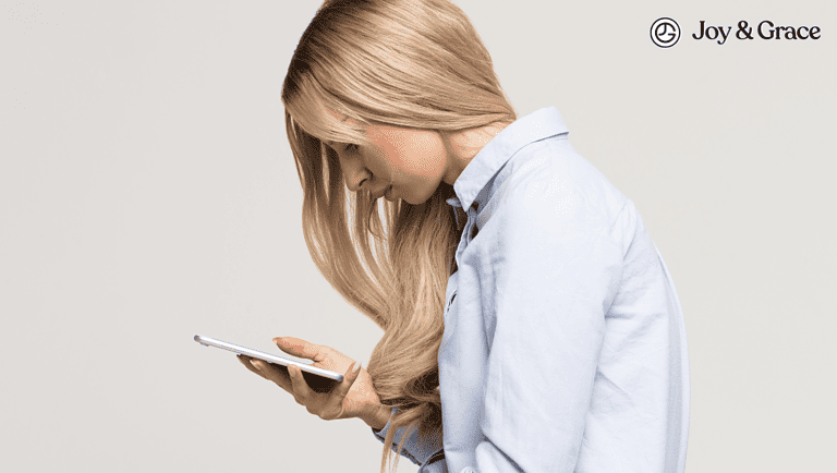 A woman experiencing neck pain due to poor posture while using her cell phone.