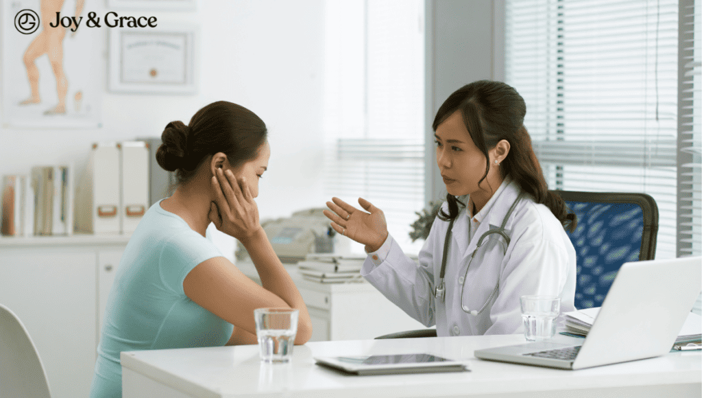 A female doctor is discussing right shoulder pain with a female patient at a desk.