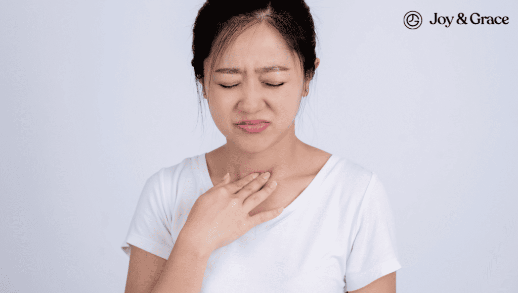 A woman is touching her chest with her hands, possibly indicating discomfort related to neck pain.