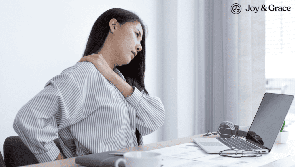 A woman is experiencing neck pain from her desk work.