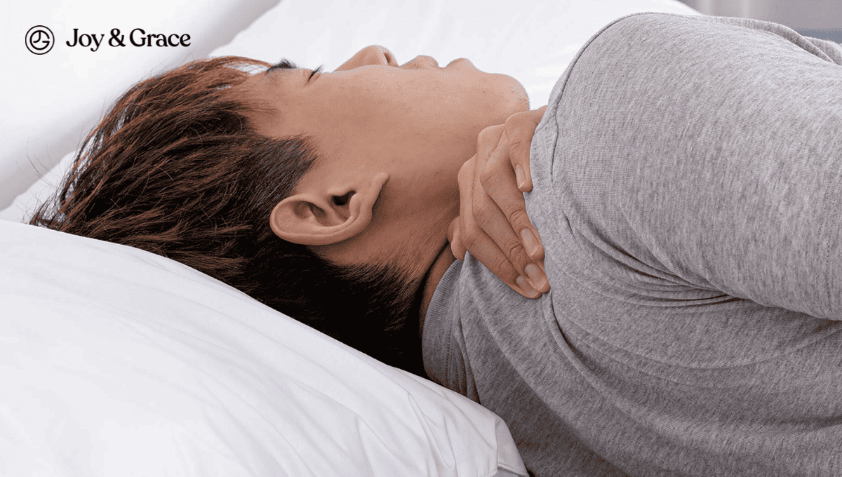 A man laying in bed experiencing neck pain.