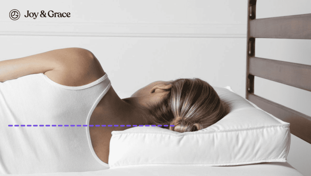 A woman finding relief from neck pain by laying on a bed with a pillow on her back.