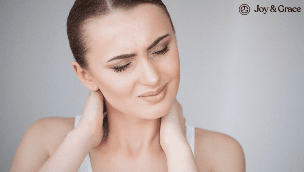 A woman is touching her neck, possibly indicating symptoms of a stiff neck.