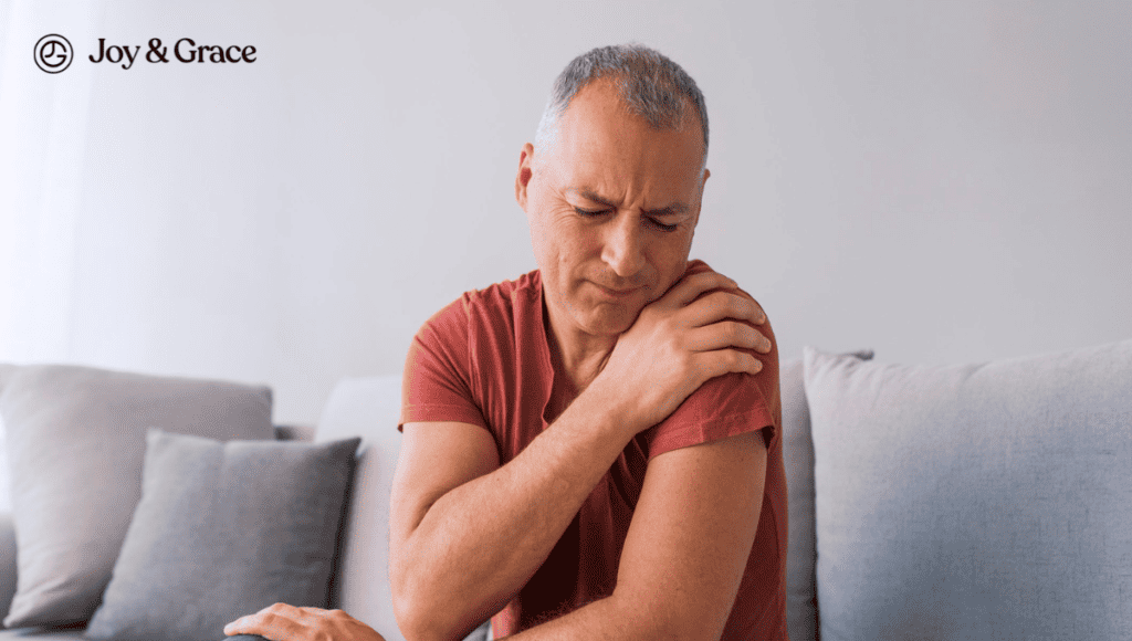 A man experiencing shoulder pain while sitting on a couch.