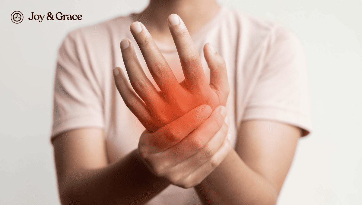 A woman experiencing numb fingers holds her hand in pain, potentially signaling a connection to neck pain.