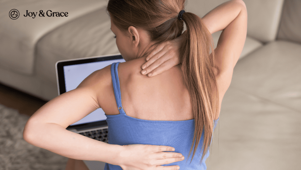 A woman experiencing neck and spine pain while sitting on a couch.