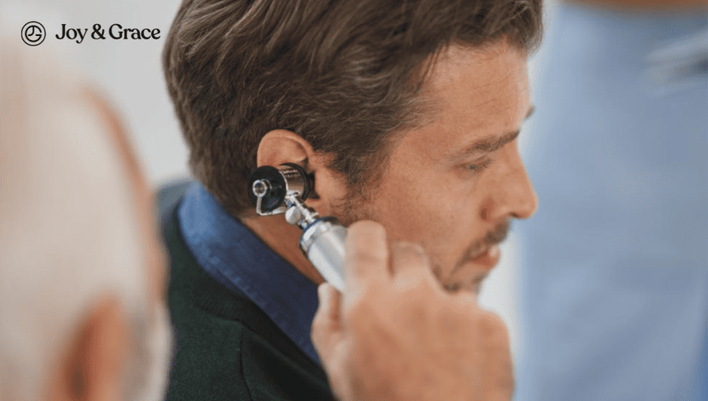 A man is using a stethoscope on his ear, possibly experiencing pain.