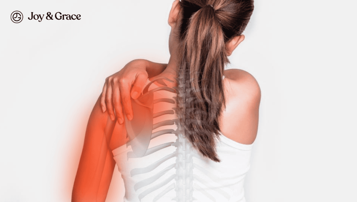 A woman experiencing pain in the back of her shoulder.