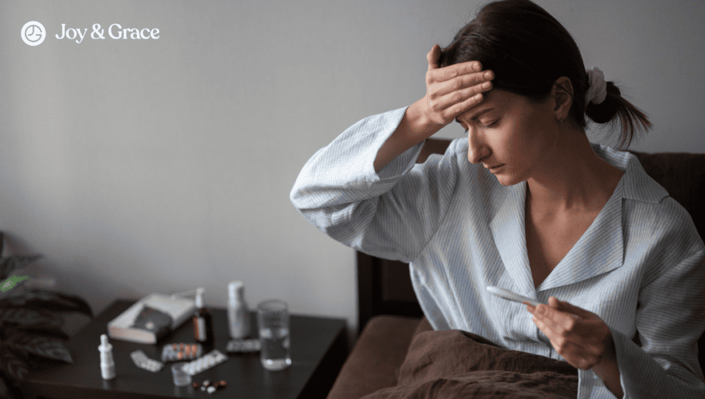 A woman in a bed holding her forehead, struggling with neck pain due to the flu.