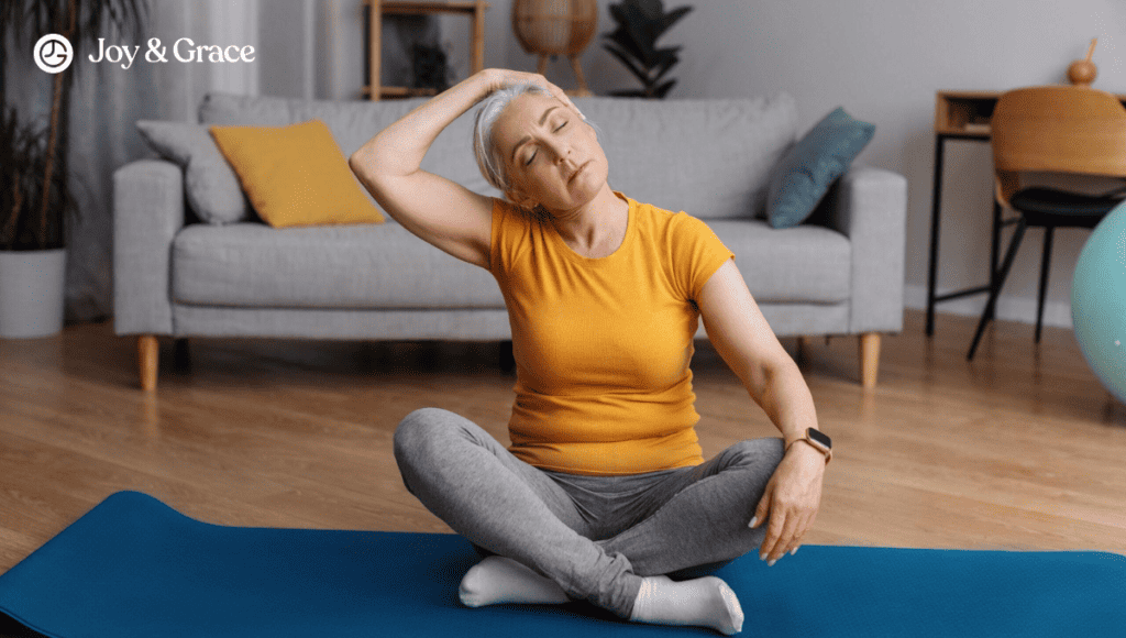 A woman is sitting on a yoga mat in a living room, performing exercises to relieve upper back and neck pain.