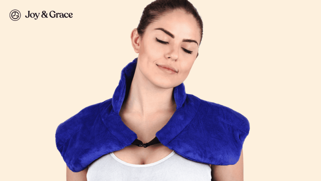 A woman experiencing shoulder pain using a blue neck wrap for heat therapy.