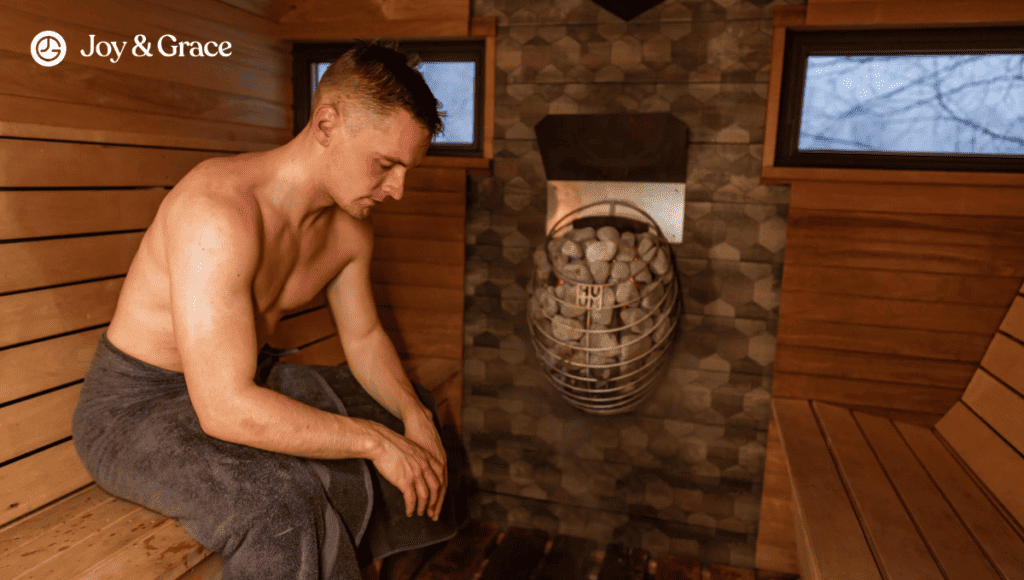 A man utilizing heat therapy to alleviate shoulder pain while sitting in a sauna.