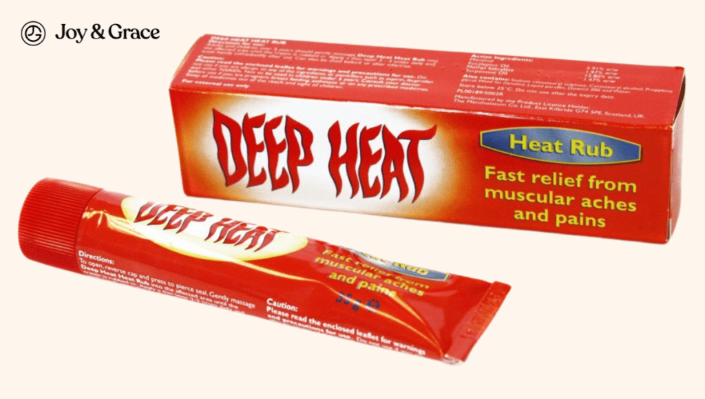 A tube of deep heat on a table next to a box, providing relief from shoulder pain through the use of heat therapies.