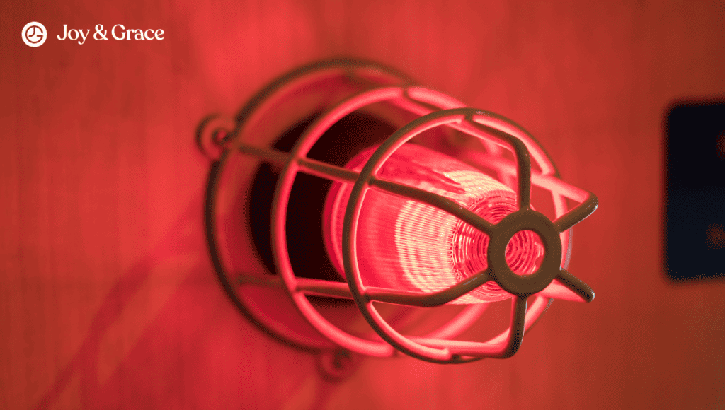 A red light on a wall in a room, casting an illuminating glow.